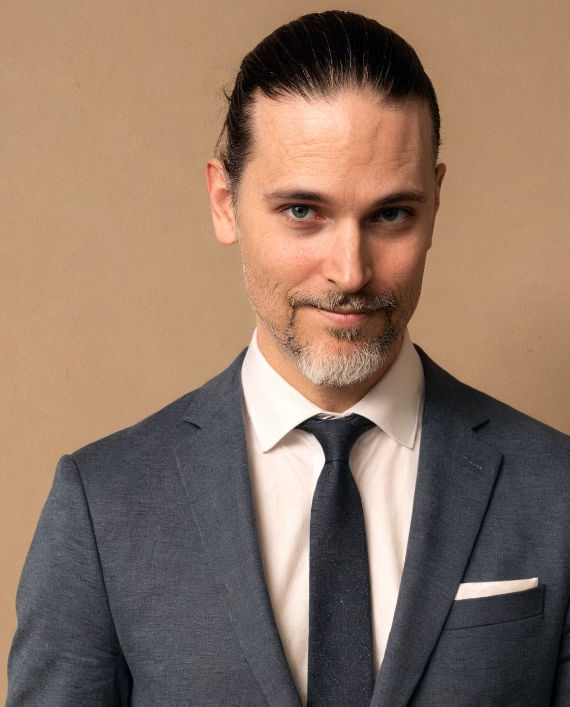 Sami Rusani, wearing a dark suit with a relaxed half-smile